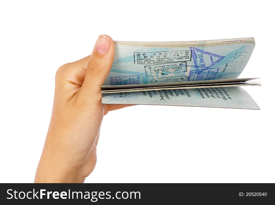 Hand holding and flipping pages of passport isolated against white background.