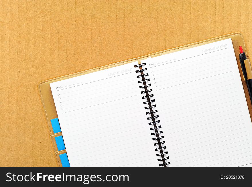 Open blank note book on cardboard