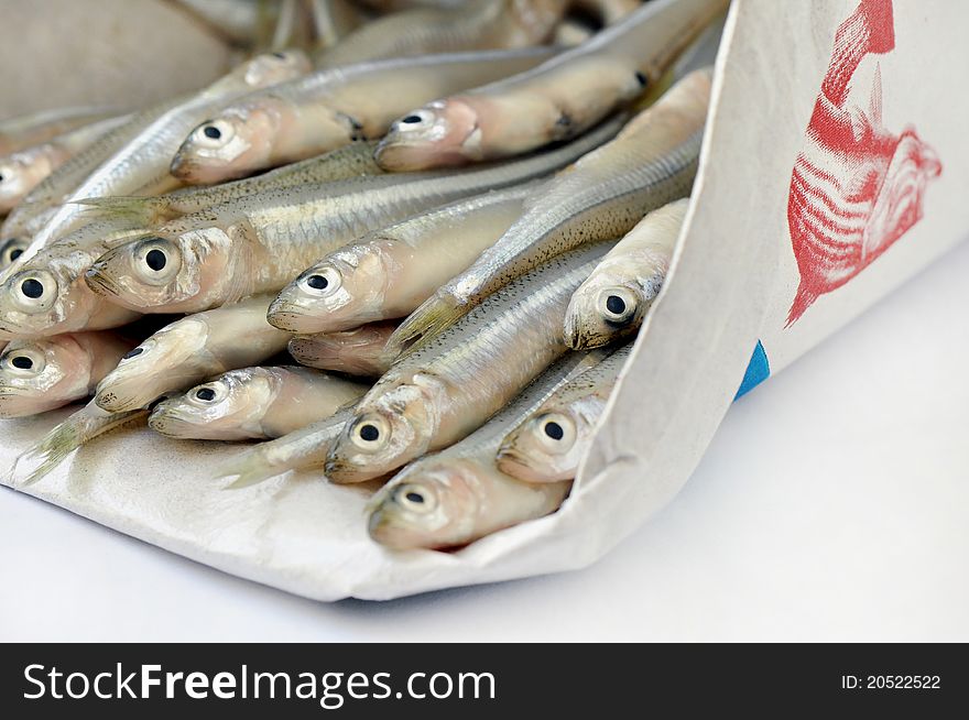 Fresh little anchovies in a paper bag. Fresh little anchovies in a paper bag