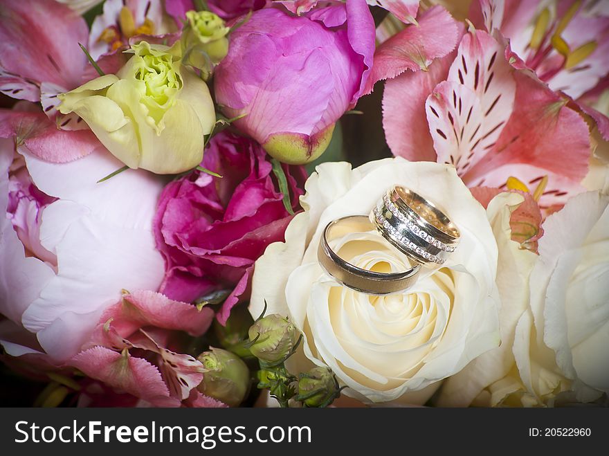 Wedding rings with precious stones in the bouquet of flowers