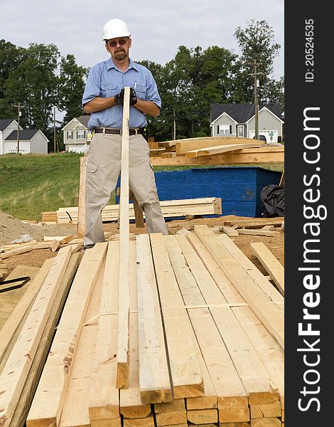 Carpenter inspecting wood before selecting the next support beam