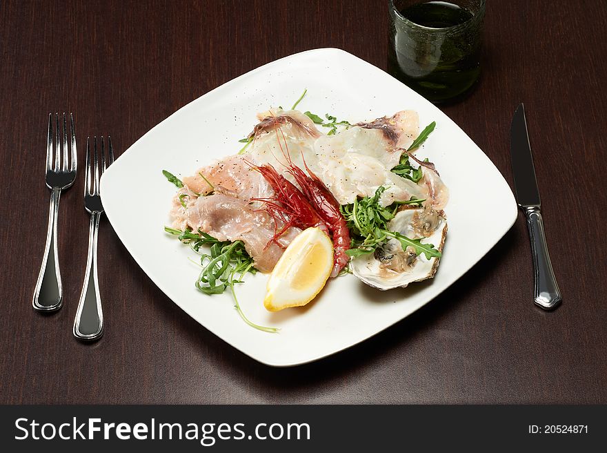 Seafood appetizer with oyster, shrimp and arugula