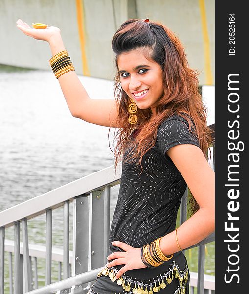 A young and modern Pakistani model holding a traditional indian lamp in her hands and posing. A young and modern Pakistani model holding a traditional indian lamp in her hands and posing