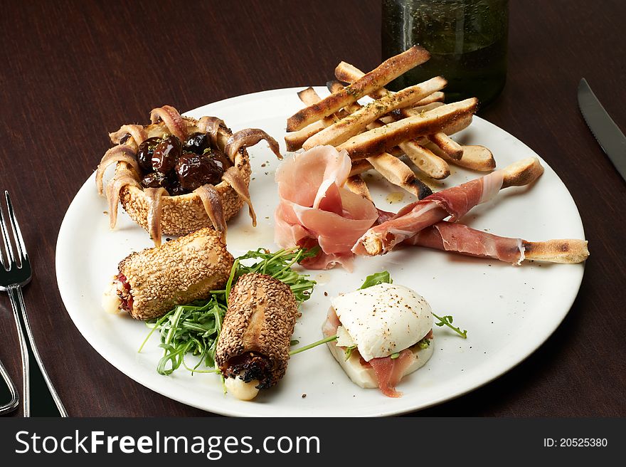 Italian appetizer with ham , mozzarella and arugula