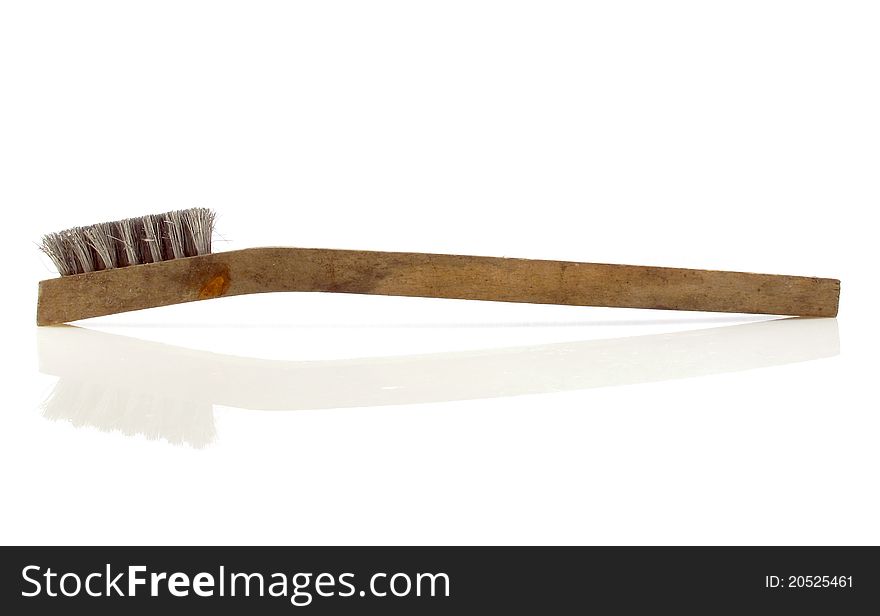 Old and well used wooden-handled wire brush on white