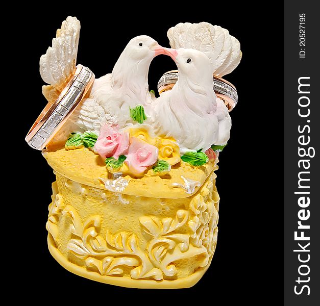 Wedding ring box with two kissing pigeons holding rings, isolated over black