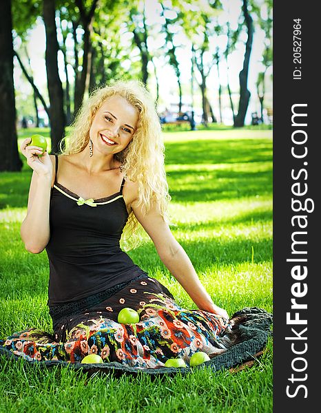 Portrait of smiling young girl sitting on the grass in the park