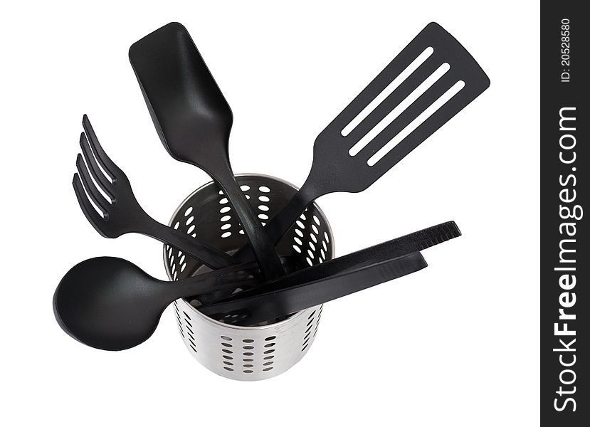 Kitchen utensils in a utensil holder isolated against a white background