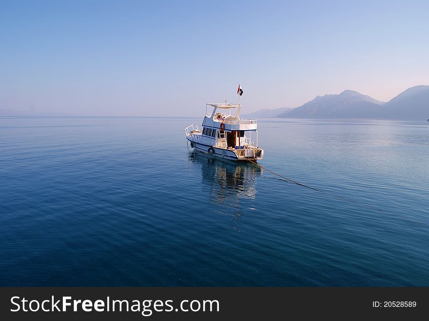 Boat on incredibly calm sea with mountains in the distance. Boat on incredibly calm sea with mountains in the distance