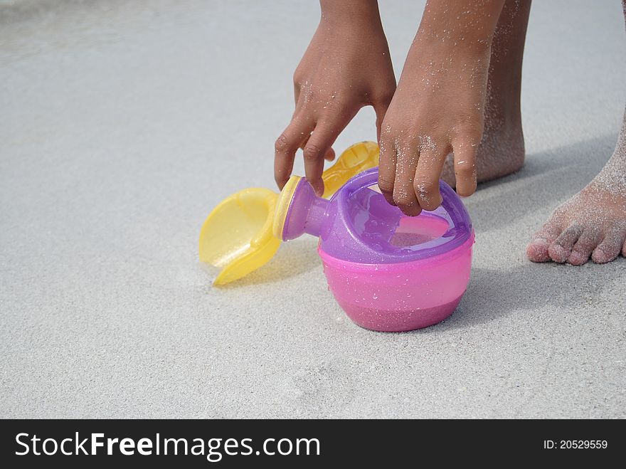 Kids hand tolding toys in the sand. Kids hand tolding toys in the sand