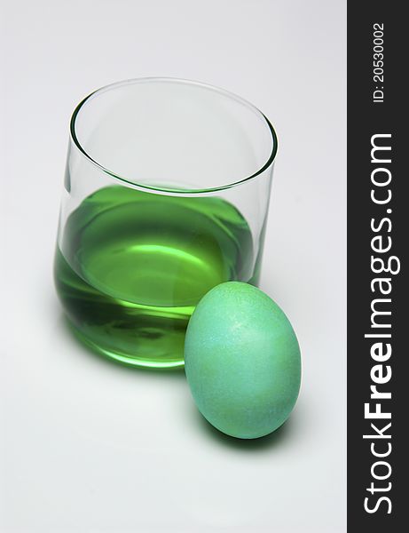 Glass of green dye and Easter egg. Glass of green dye and Easter egg