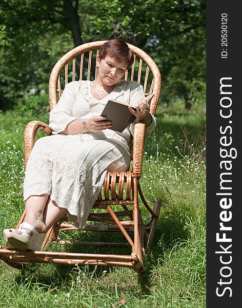 Mature woman reading book in rocking chair