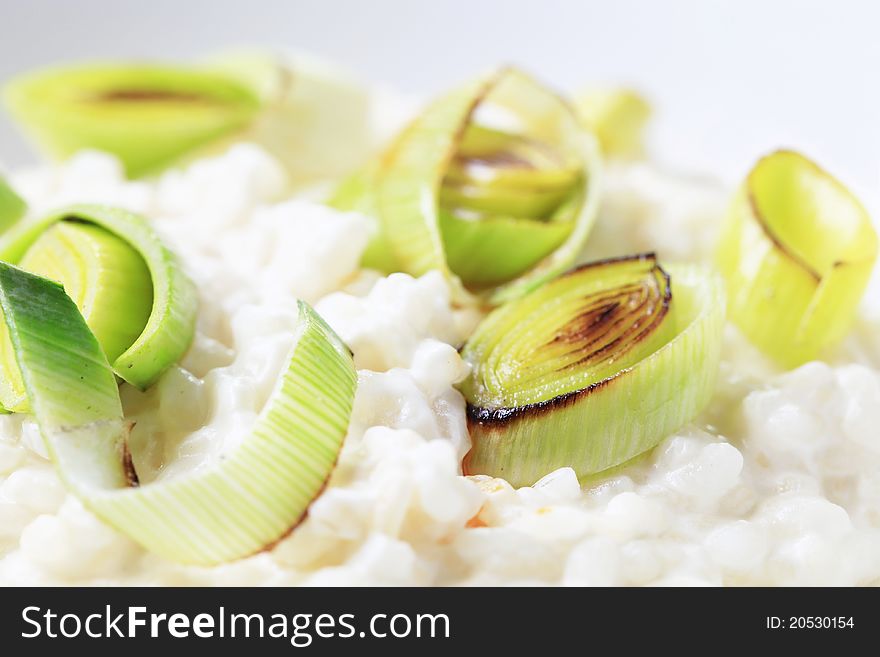 Bowl of rice pudding garnished with leek