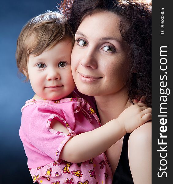 Close-up portrait of beautiful mother with cute young girl on dark background. Close-up portrait of beautiful mother with cute young girl on dark background