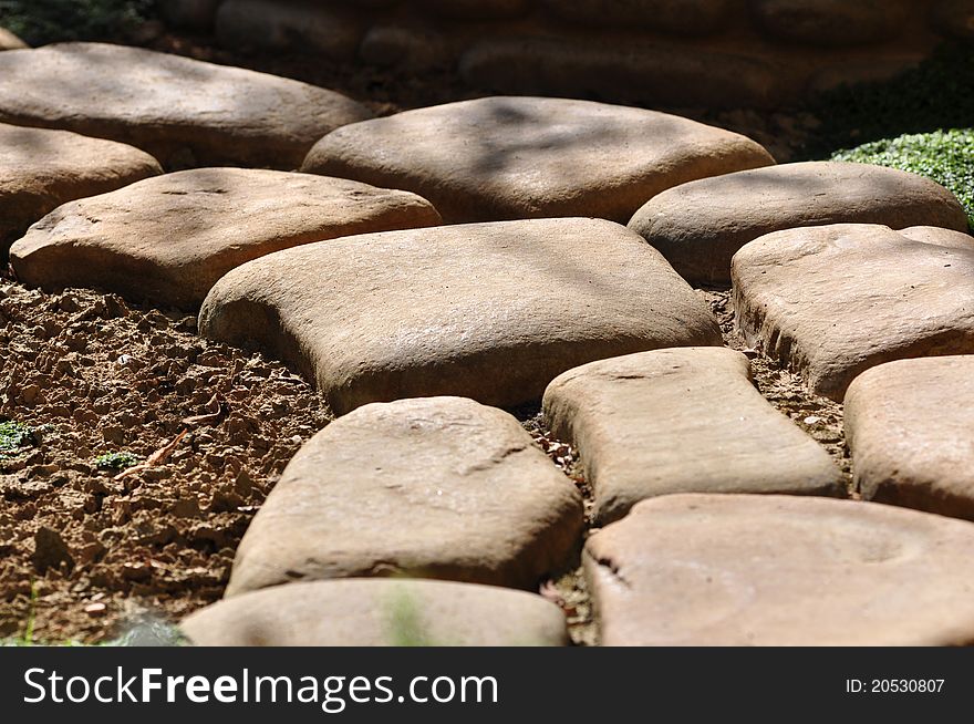 Big stones placed on the ground to form a curved pathway. Big stones placed on the ground to form a curved pathway