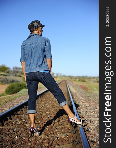 Woman in High Heel Shoes Standing on Railway Track in remote Outback of Australia. Woman in High Heel Shoes Standing on Railway Track in remote Outback of Australia.