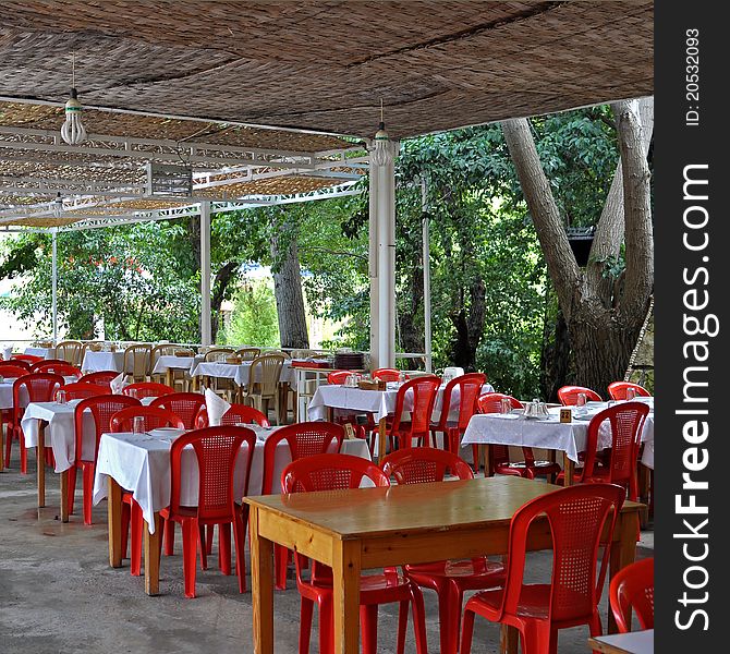 A Lebanese restaurant where the setting is of wooden tables and plastic chairs; shaded with woven hay. What is of importance is the natural surrounding. A Lebanese restaurant where the setting is of wooden tables and plastic chairs; shaded with woven hay. What is of importance is the natural surrounding