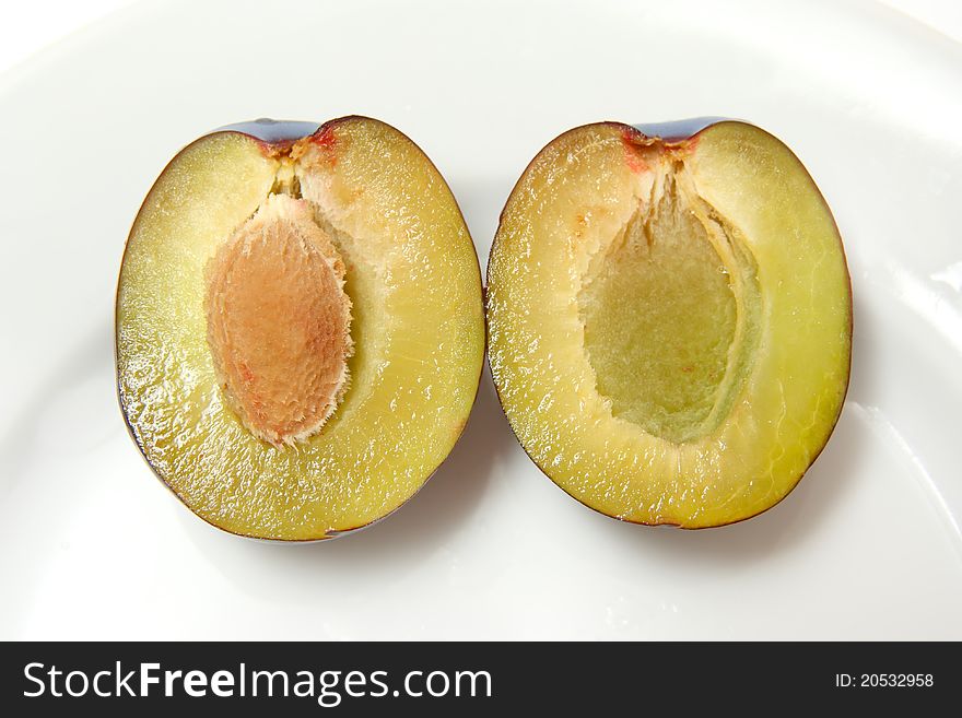 Ripe plums on porcelain plate