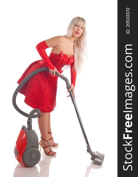 The sexual blonde in a celebratory dress with the vacuum cleaner in hands, on a white background