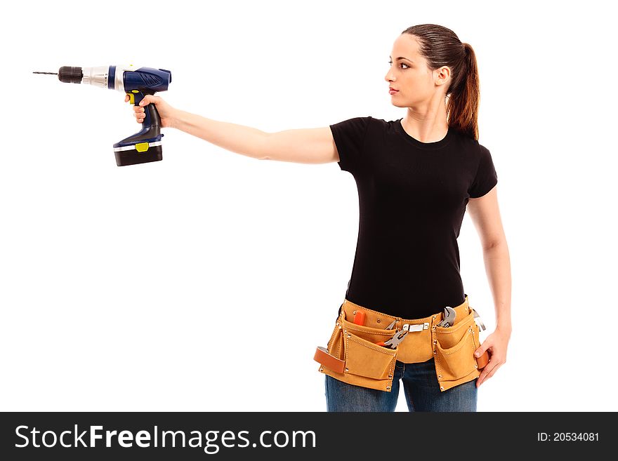 Young female dressed in black top blue jeans waering a tool belt holding a cordless electric drill on a white isolated background. Young female dressed in black top blue jeans waering a tool belt holding a cordless electric drill on a white isolated background