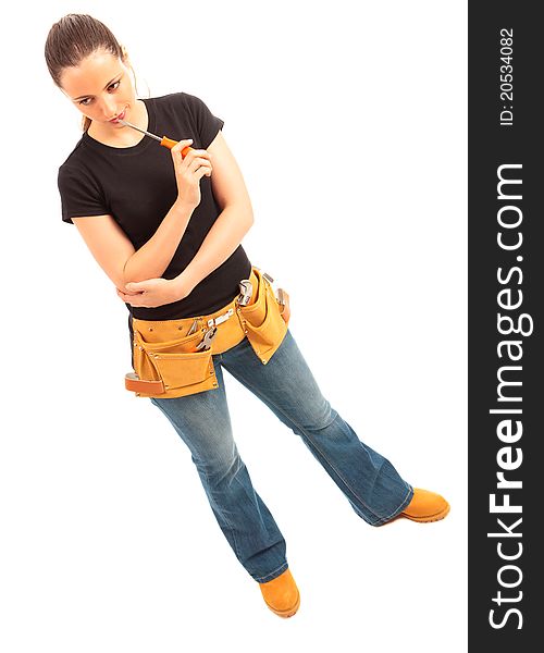 Young female dressed in black top blue jeans wearing a tool belt holding a screwdriver on a white isolated background. Young female dressed in black top blue jeans wearing a tool belt holding a screwdriver on a white isolated background