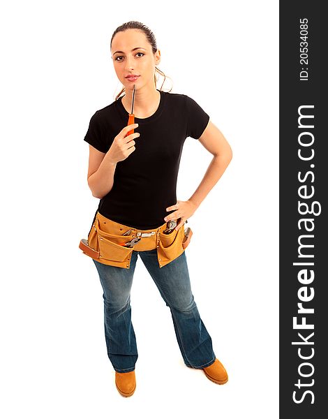 Young female dressed in black top blue jeans waering a tool belt holding a screwdriver on a white isolated background. Young female dressed in black top blue jeans waering a tool belt holding a screwdriver on a white isolated background