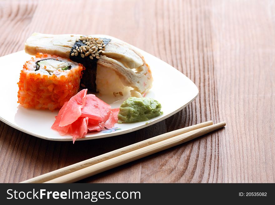 Japanese traditional cooked sushi and chopsticks on wooden surface. Japanese traditional cooked sushi and chopsticks on wooden surface