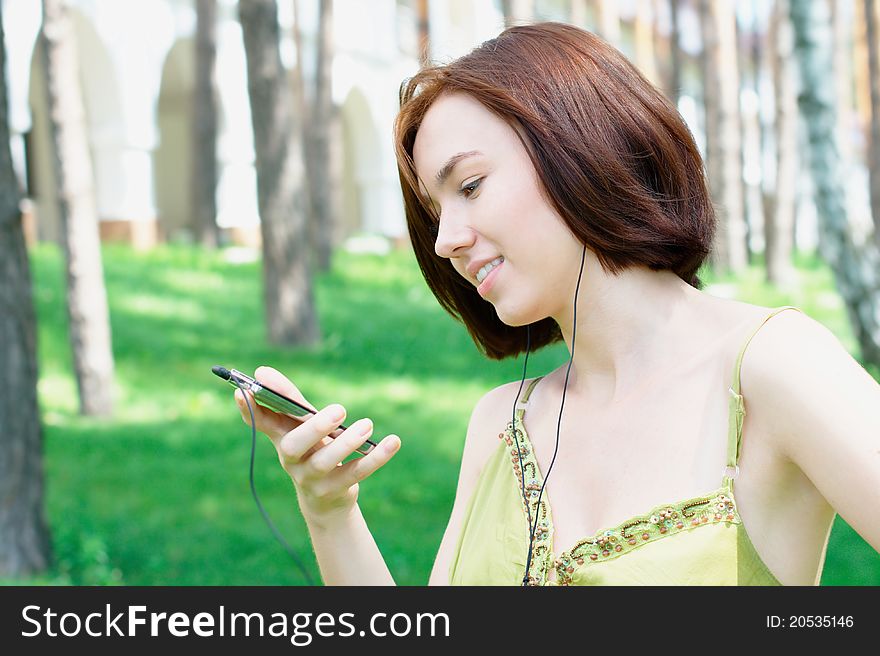 Photo of a girl listening to music at the park with copy space. Photo of a girl listening to music at the park with copy space
