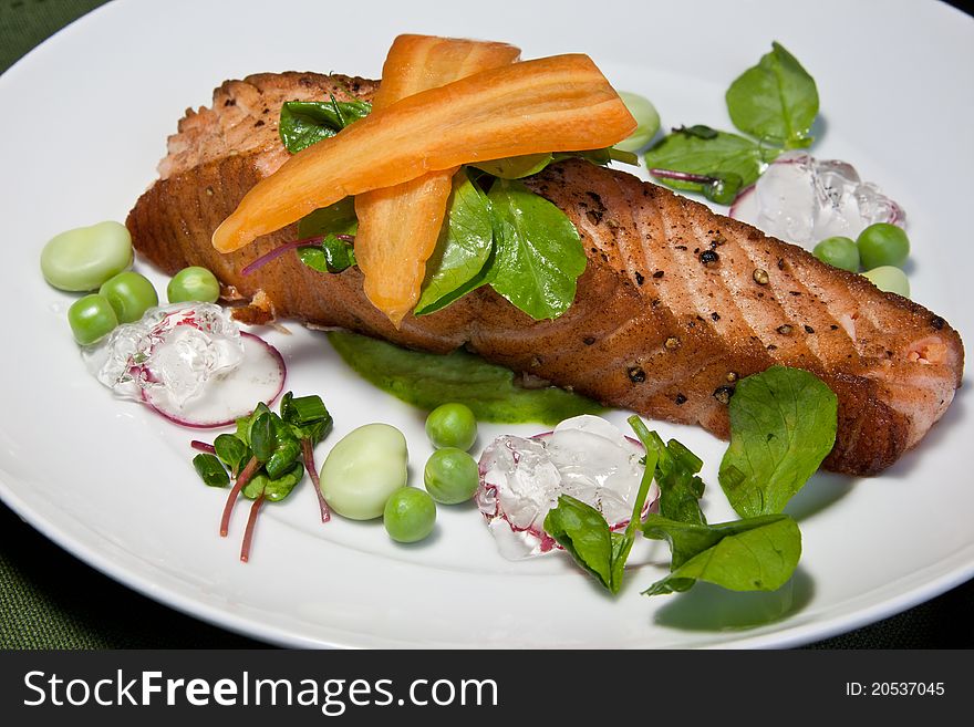 A panfried salmon steak on a pea puree garnished with radish, raw peas, broad beans, micro herbs, pea shoots, sliced carrot & a ginger jelly. A panfried salmon steak on a pea puree garnished with radish, raw peas, broad beans, micro herbs, pea shoots, sliced carrot & a ginger jelly