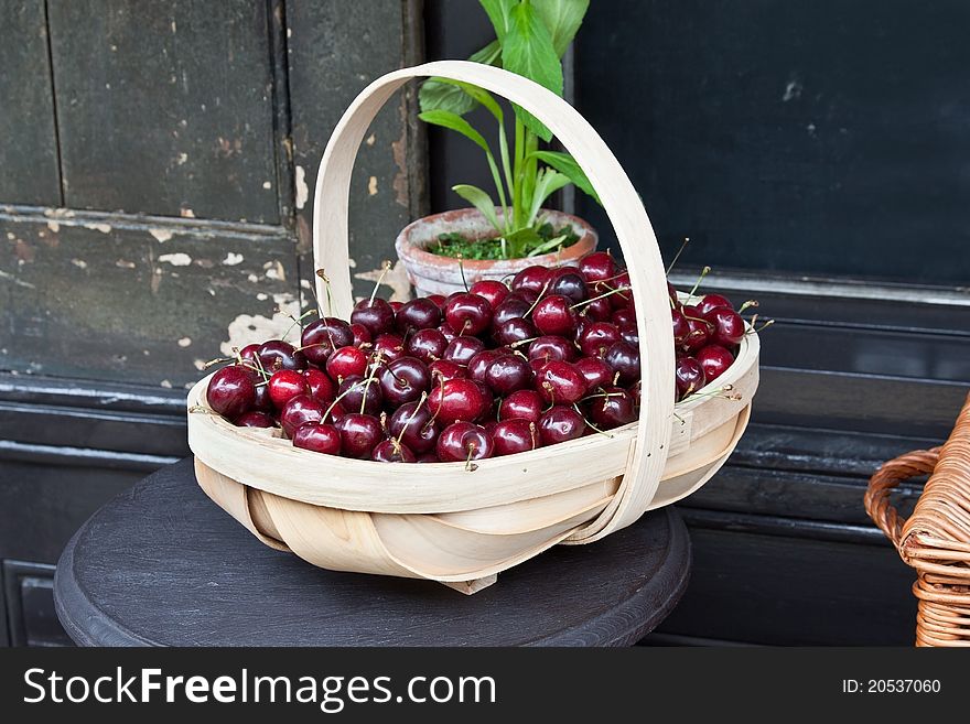 A basket, or trug, of cherries outside a traditional greengrocer's shop. A basket, or trug, of cherries outside a traditional greengrocer's shop