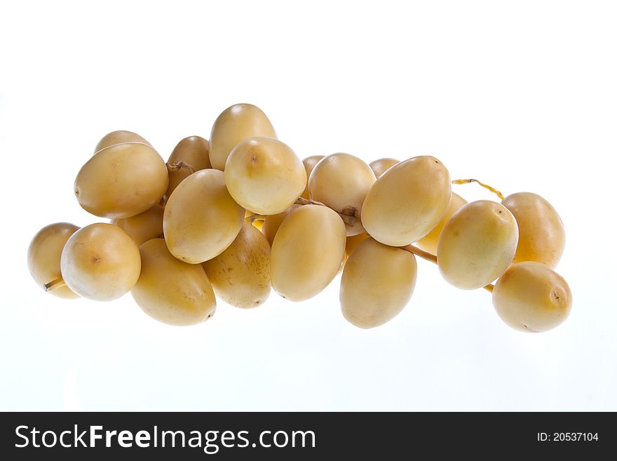 A cluster of fresh dates on a stalk isolated against a white background