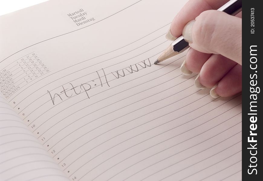 Hand with pencil writing an url, starting with http. Hand with pencil writing an url, starting with http