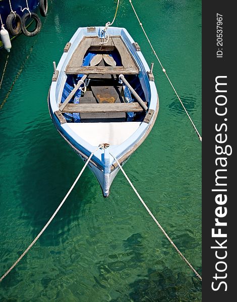 Old wooden fishing boat berthed in the crystal clear emerald waters of Jadranovo with the boat`s shadow on the seabed. Old wooden fishing boat berthed in the crystal clear emerald waters of Jadranovo with the boat`s shadow on the seabed