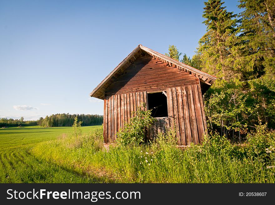 A red barn on a field next to the woods