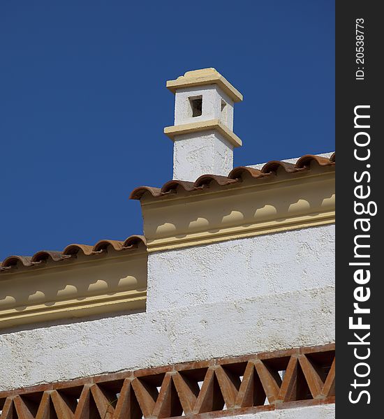 A distinctive white painted Spanish roof and chimney