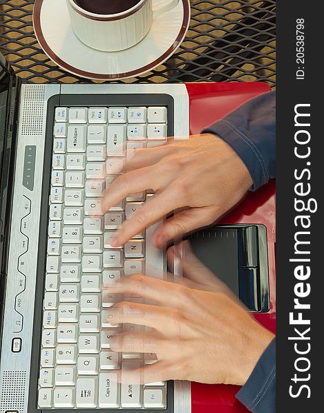 Close up of a woman's hands in motion typing on a red laptop. Close up of a woman's hands in motion typing on a red laptop.