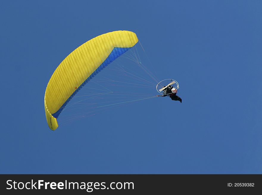 Para glider flying in a perfect blue sky