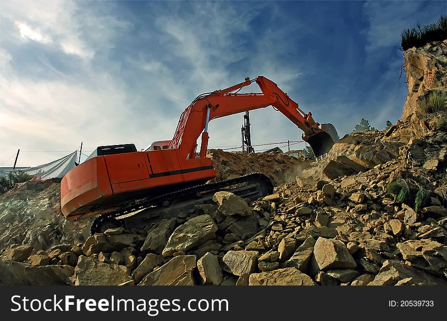 Excavator digging mountain by crushing rocks with its shovel. Excavator digging mountain by crushing rocks with its shovel