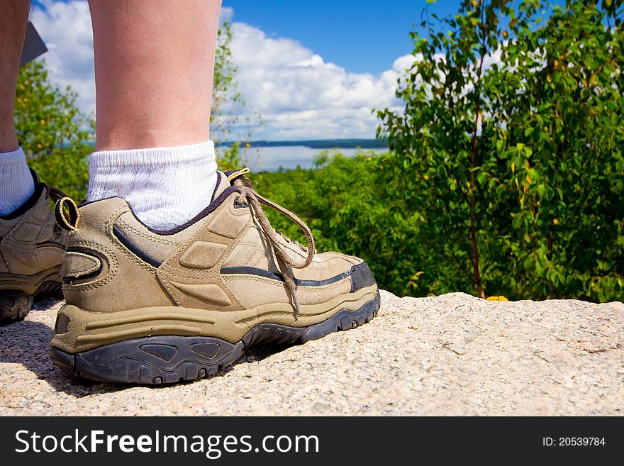 Closeup of a hikers rugged shoe as he stands on a rock looking at a natural landscape. Closeup of a hikers rugged shoe as he stands on a rock looking at a natural landscape