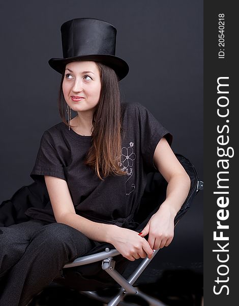 Beautiful smiling girl in a black hat on a dark background