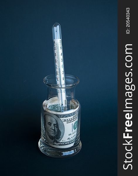 Rolled dollar banknotes in glass jar and a thermometer. Rolled dollar banknotes in glass jar and a thermometer