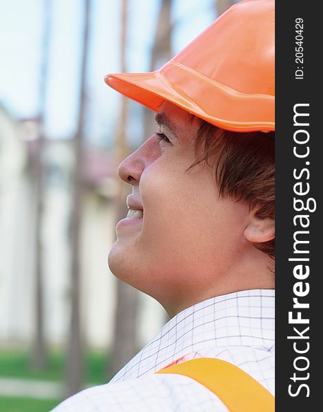 Young worker outdoors looking at the building with copy space