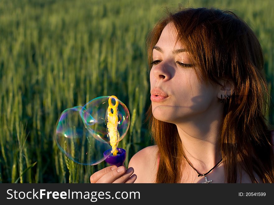 A young woman blowing bubbles. A young woman blowing bubbles