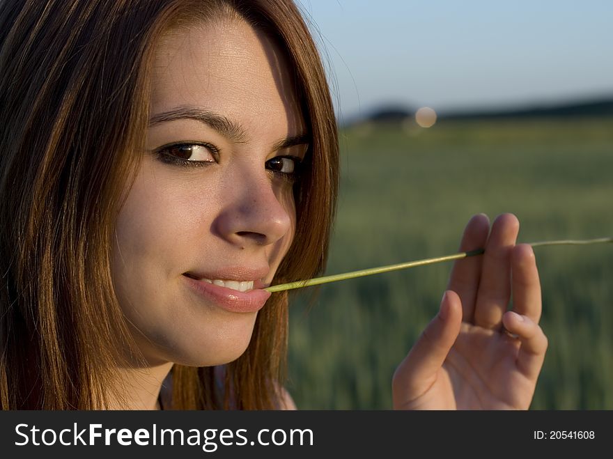 Portrait of young woman with straw in a field. Portrait of young woman with straw in a field