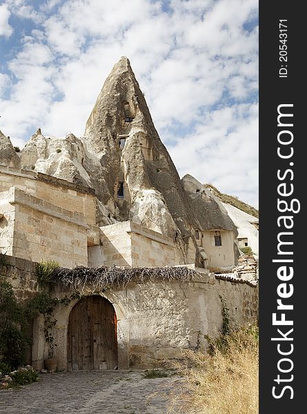 House built into limestone caves with limestone, sandstone bricks, wood door with archway, portrait, copy space. House built into limestone caves with limestone, sandstone bricks, wood door with archway, portrait, copy space