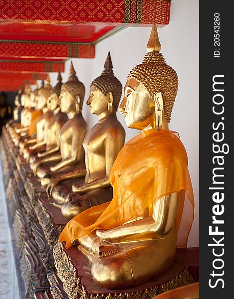 A row of Buddha statues in a temple in Bangkok, Thailand