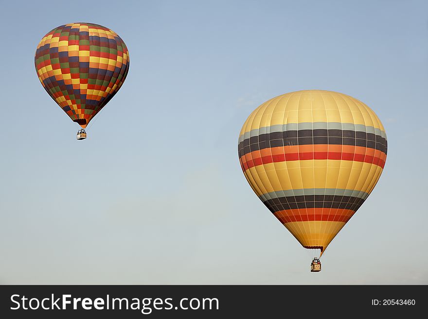 Two multi-colored balloons blue sky