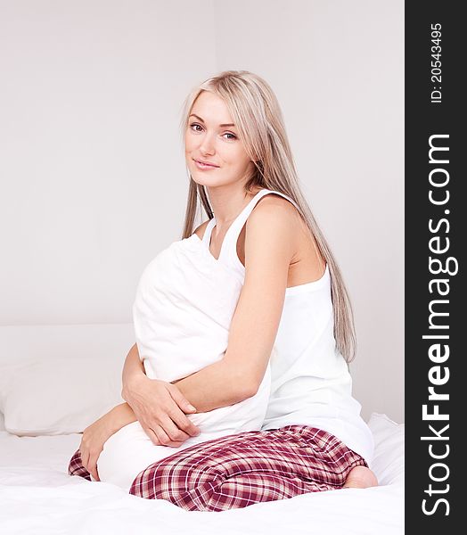 Beautiful young blond woman on the bed at home. Beautiful young blond woman on the bed at home