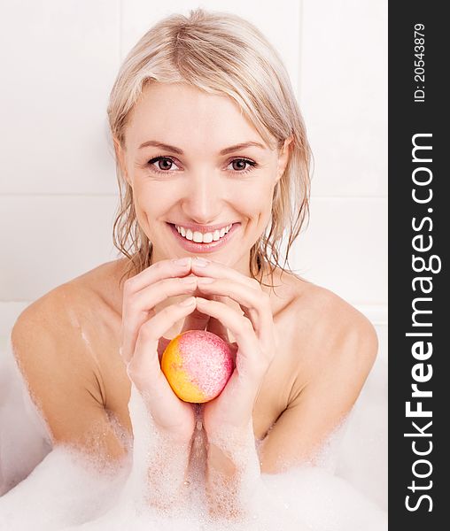 Beautiful young blond woman taking a bath and using an aromatized geyser