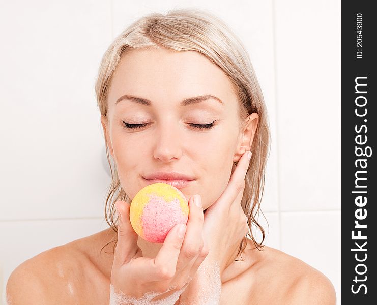 Beautiful young blond woman taking a bath and using an aromatized geyser